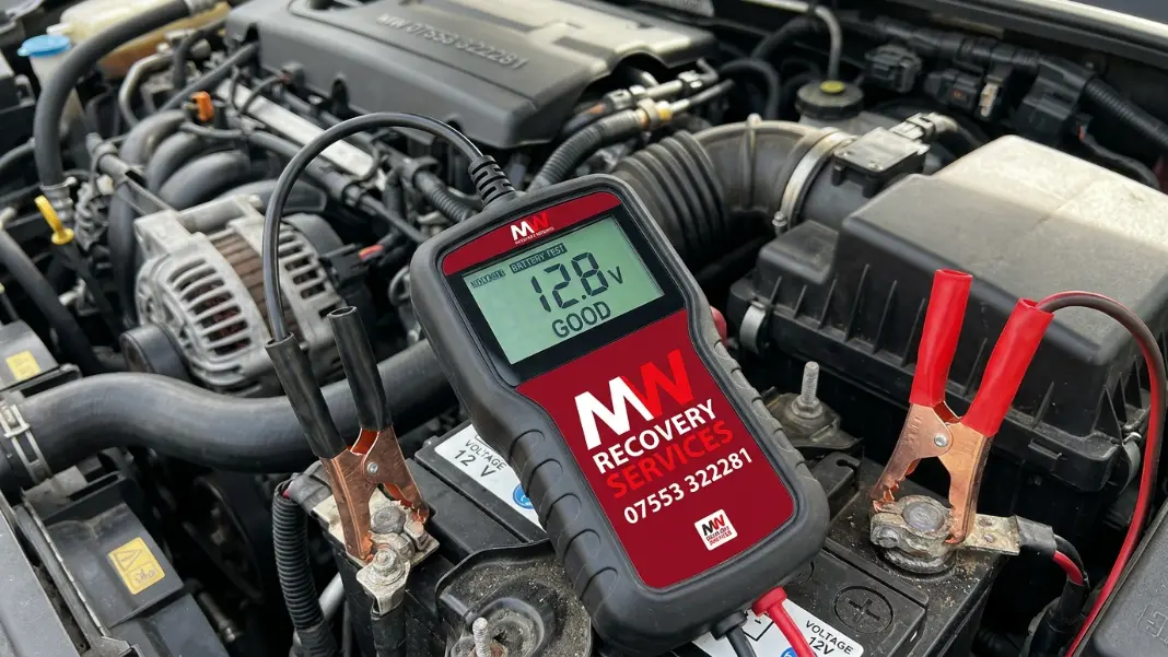 Digital battery tester showing voltage reading on a car battery in Oldham